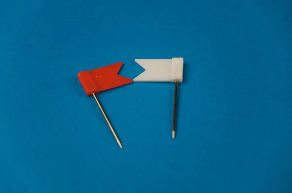 Красный и белый флаги, лежащие на синем фоне — стоковое фото