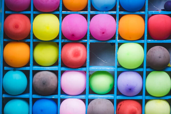 a bunch of colorful balloons on a wooden shelf