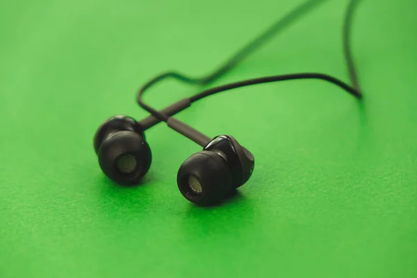 Auriculares negros sobre fondo verde —  Fotos de Stock