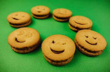 yeşil arka planda lezzetli kurabiyegülümsüyor.