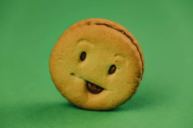 yeşil arka planda lezzetli kurabiyegülümsüyor.