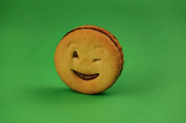 yeşil bir arka plan üzerinde gülümseyen çerezler ve farklı duygular