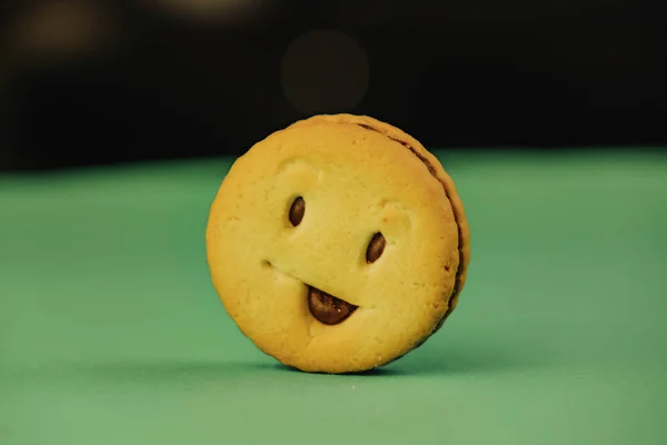 Biscoitos sorridentes e emoções diferentes em um fundo verde — Fotografia de Stock