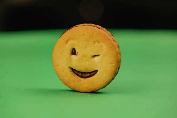 Biscotti sorridenti ed emozioni diverse su sfondo verde — Foto Stock