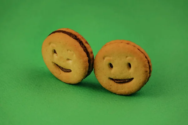 Biscoitos sorridentes e emoções diferentes em um fundo verde — Fotografia de Stock