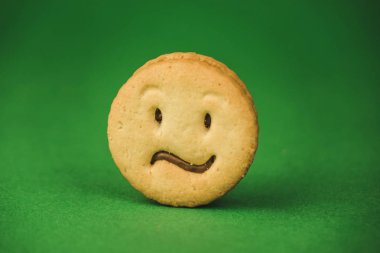 yeşil bir arka plan üzerinde gülümseyen çerezler ve farklı duygular