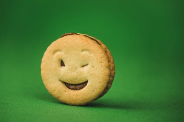 yeşil bir arka plan üzerinde gülümseyen çerezler ve farklı duygular