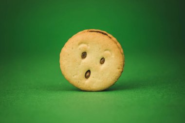 yeşil bir arka plan üzerinde gülümseyen çerezler ve farklı duygular