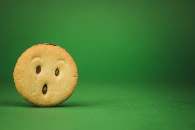 yeşil bir arka plan üzerinde gülümseyen çerezler ve farklı duygular