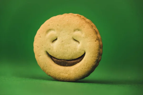 Χαμογελαστά μπισκότα και διαφορετικά συναισθήματα σε πράσινο φόντο — Φωτογραφία Αρχείου