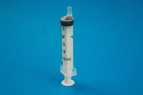 Medical syringe lying on a blue background — Stock Photo, Image