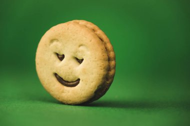 yeşil bir arka plan üzerinde gülümseyen çerezler ve farklı duygular