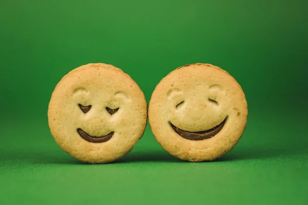 Uśmiechnięte ciasteczka i różne emocje na zielonym tle — Zdjęcie stockowe