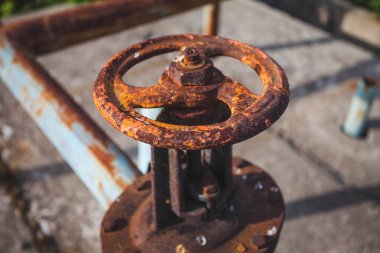 Duvarda eski paslı bir gaz kontrol valfi. Büyük bir sistemde endüstriyel vana. Paslı borular. Eski su vanası.