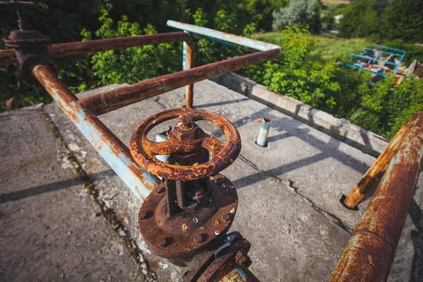 Una vieja válvula de control de gas oxidado en la pared. Válvula industrial en un sistema grande. Tubos oxidados. Válvula antigua . — Foto de Stock
