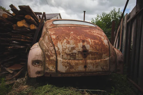 Ένα παλιό σκουριάσει έξω θραύσματα αυτοκίνητο που έχει εγκαταλειφθεί στο δάσος. — Φωτογραφία Αρχείου