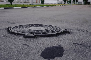 Kuyunun Metal Kapağı kapalı. Su için ambar. Asfalt çevresinde.