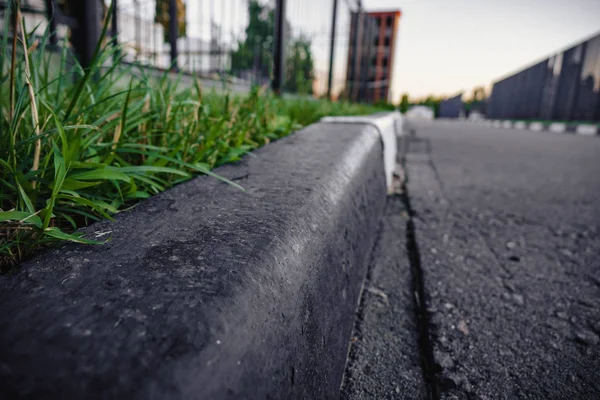 Una hierba verde con borde de hormigón gris . — Foto de Stock