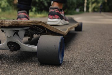Atlet ayağı ile Longboard dağlarda yolda. Güneş ışığı.