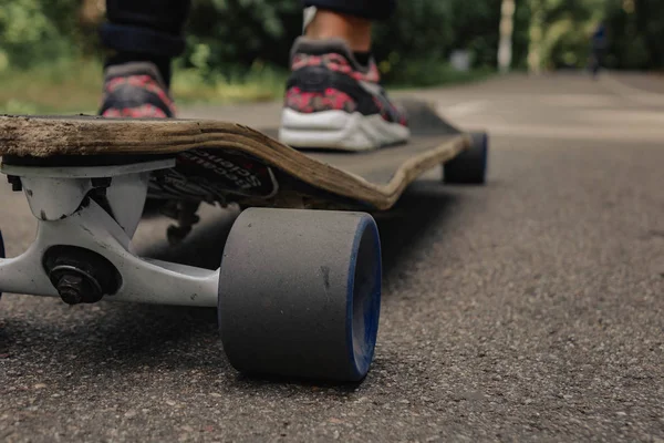 Atlet ayağı ile Longboard dağlarda yolda. Güneş ışığı.