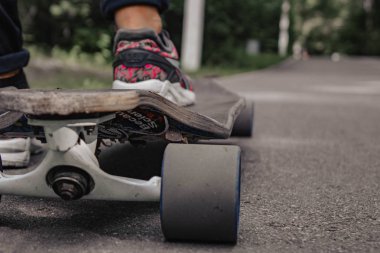 Atlet ayağı ile Longboard dağlarda yolda. Güneş ışığı.