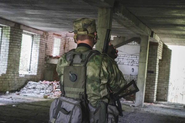 Militar en una estructura de piedra es con armas en el listo, listo para disparar —  Fotos de Stock