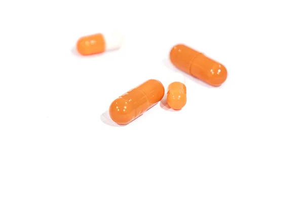 Comprimidos de color naranja, aislados sobre un fondo blanco. medicina . — Foto de Stock