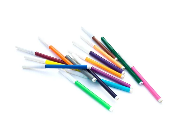 Značky a barevné tužky jsou náhodně rozptýlené. Izolované přes bílé pozadí — Stock fotografie