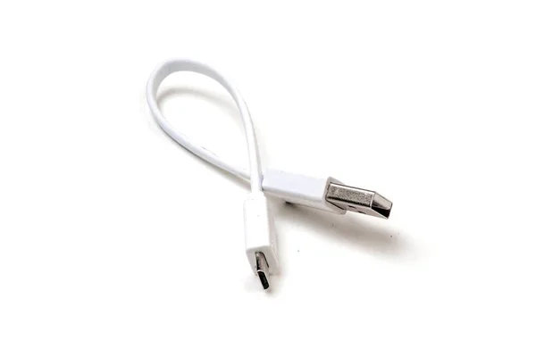 Micro USB witte kabel zet op houten tafel, het is klein en kort voor draagbaarheid. geïsoleerd op witte achtergrond. — Stockfoto