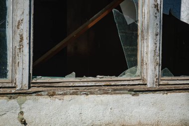büyük, terk edilmiş bir binada kırık cam