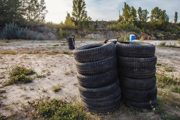 Um monte de velhos pneus de borracha deitados uns em cima dos outros — Fotografia de Stock