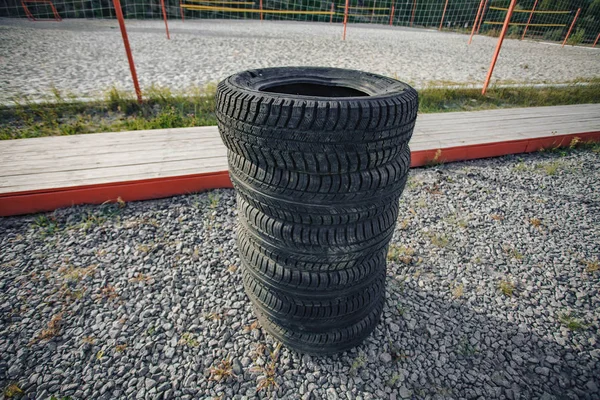 Neumáticos de goma de coche que yacen uno encima del otro . —  Fotos de Stock
