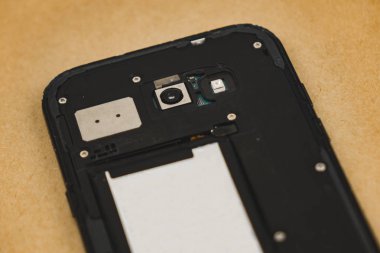 Kahverengi arka plan üzerinde izole sökülmüş cep telefonu