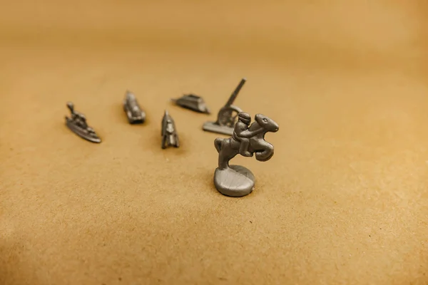 silver miniature figurines standing on a gray background