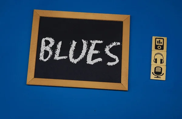 Inscripción BLUES en un tablero negro con un fondo azul con tres cubos de madera —  Fotos de Stock