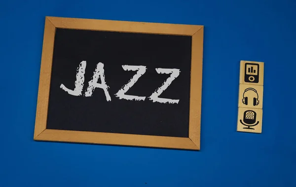 在黑板上刻有爵士乐，有蓝色背景，有三个木立方体 — 图库照片
