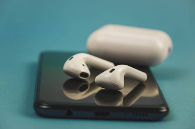 Berlin Almanya 03.11.2019. Apple kulaklıklar siyah bir telefon üzerinde yalan.