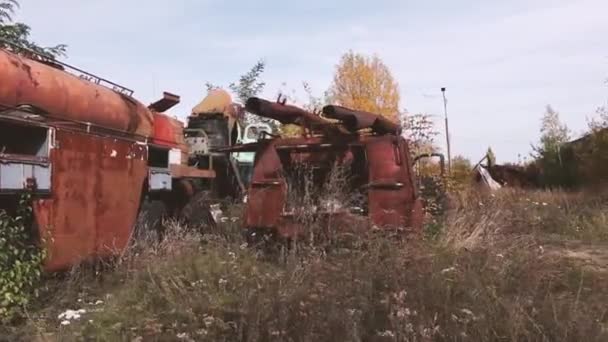 Närbild av gamla rostiga övergivna bil med skalning färg stående i trä utomhus — Stockvideo