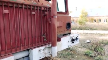 Eski, paslı, terk edilmiş arabanın ahşap duvarda duran boyasının yakın görüntüsü..