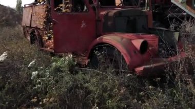 Eski, paslı, terk edilmiş arabanın ahşap duvarda duran boyasının yakın görüntüsü.