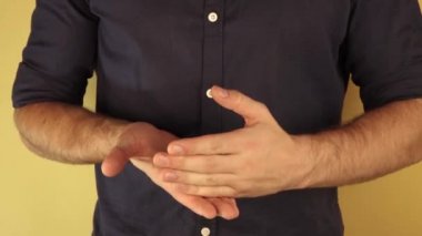 Gömlekli adam bir sürü el hareketi yapar..