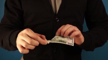 Siyah ceketli adam faturayı yırtıyor.