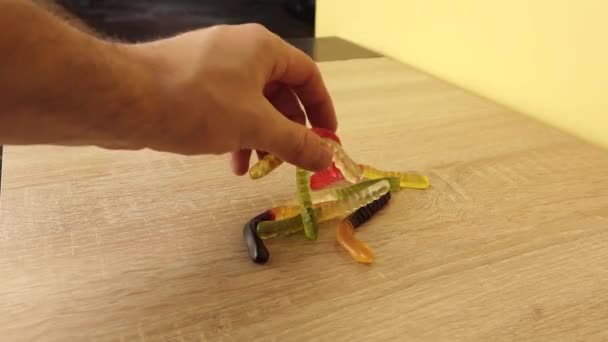 Mannen tar en handfull marmelad i ett stycke, biter av hälften av den och kastar tillbaka den — Stockvideo