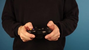 Moskova Rusya 20 Eylül 2019. Siyah kapüşonlu bir adam mavi arka planda bir Xbox kumandası tutuyor..