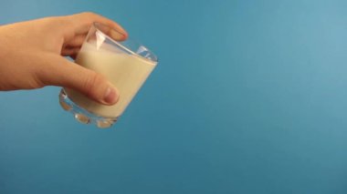 Bir erkek eli usulca bir bardak kefir doldurur.