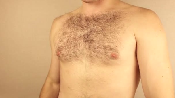 Мужчина трогает свою волосатую грудь — стоковое видео