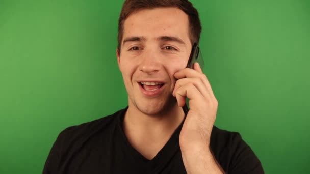 Un uomo che parla al telefono il cui umore cambia su uno sfondo verde — Video Stock