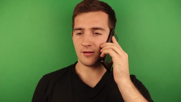 Hombre feliz hablando por teléfono sobre un fondo verde — Vídeos de Stock