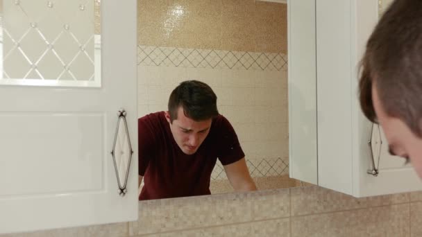 Un hombre enfermo estornuda en el baño — Vídeo de stock