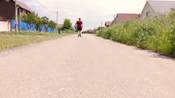 Um homem corre com um cão na rua — Vídeo de Stock